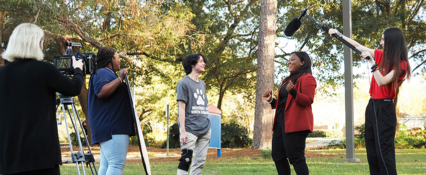 Broadcast Journalism Students filming outside on campus.