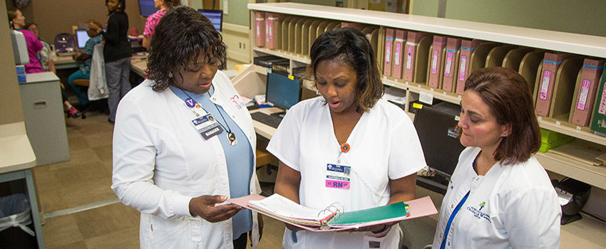 Nurses at work station reviewing chart