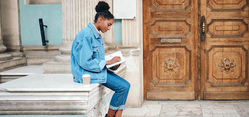 Image of young woman writing in a journal