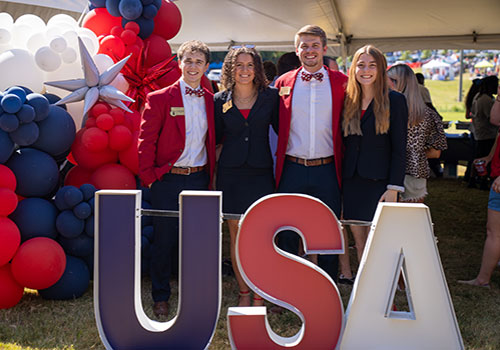Southerners at Tailgate event behind USA sign