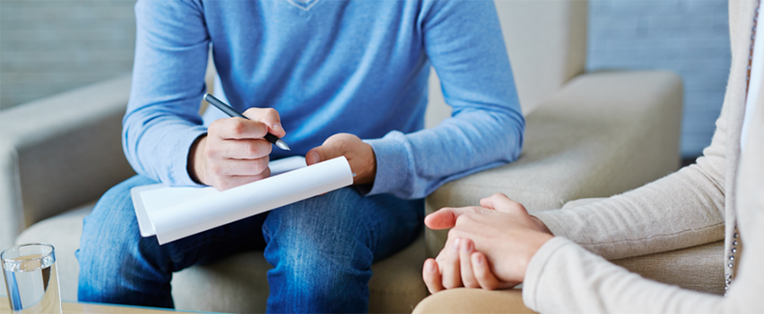 Counselor taking notes in a counseling session.