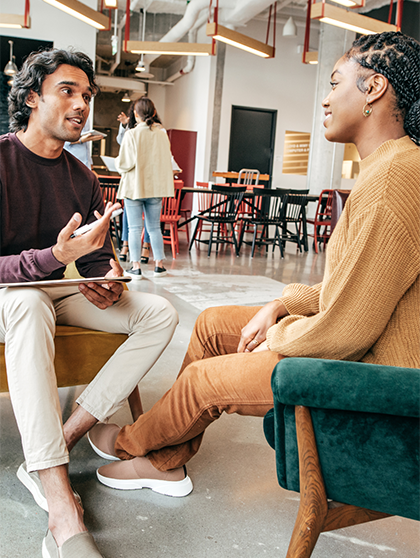 Employer talking to student sitting in chairs.