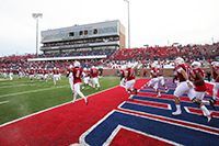 media relations photography - football team entering abraham mitchell field 